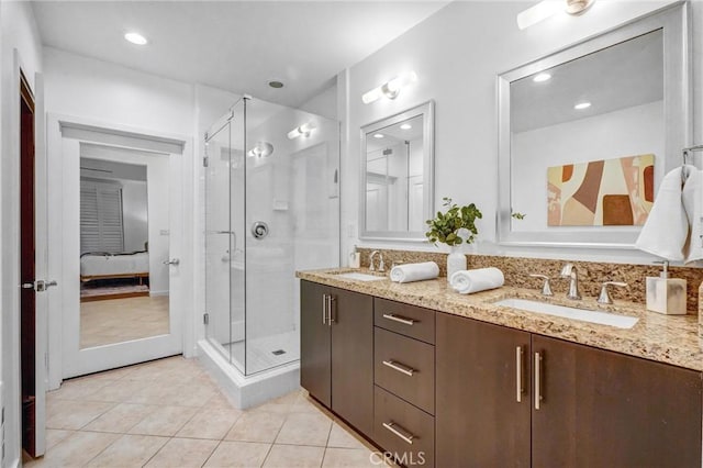 bathroom featuring vanity, a shower with shower door, and tile patterned floors