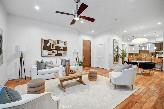 living room featuring light hardwood / wood-style floors and ceiling fan