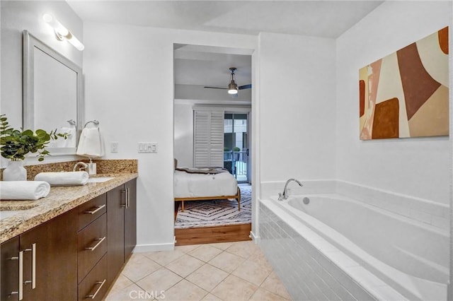 bathroom featuring ceiling fan, tiled tub, tile patterned floors, and vanity