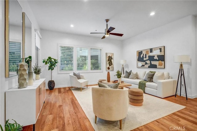 living room featuring light hardwood / wood-style flooring and ceiling fan