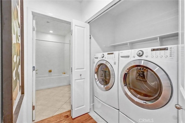 laundry room with washer and clothes dryer and light tile patterned flooring