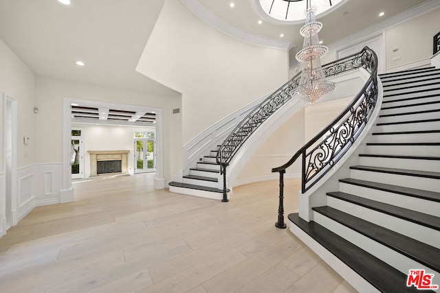 stairway with ornamental molding, coffered ceiling, and hardwood / wood-style floors