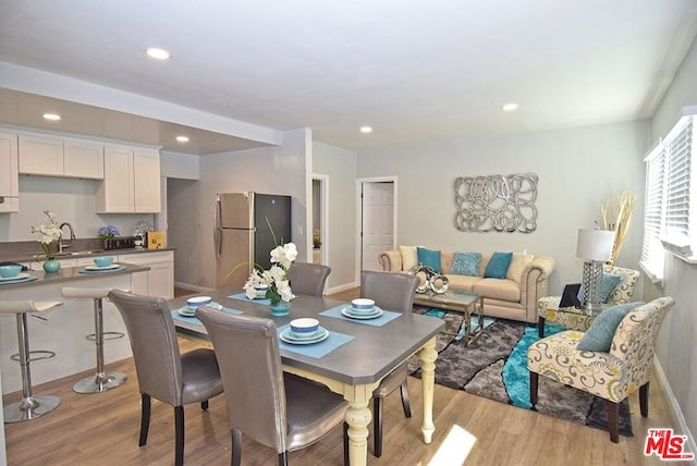 dining room with light hardwood / wood-style floors and sink