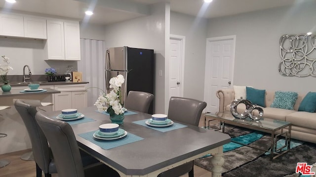 dining area featuring sink and wood-type flooring