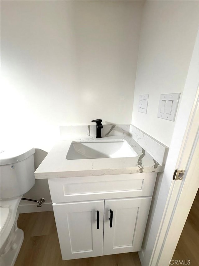 bathroom featuring vanity, toilet, and wood-type flooring