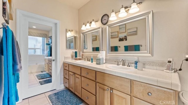 bathroom with tile patterned flooring, a sink, a bath, and double vanity