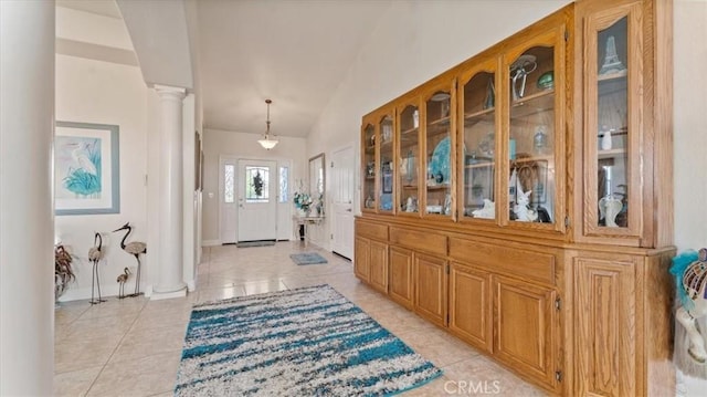 entryway featuring decorative columns and light tile patterned flooring