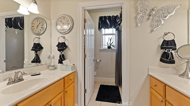 bathroom featuring vanity, baseboards, and tile patterned floors