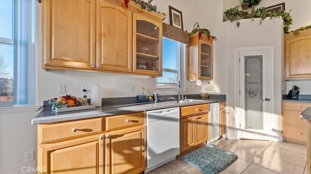 kitchen with light tile patterned floors, stainless steel dishwasher, glass insert cabinets, a sink, and dishwasher