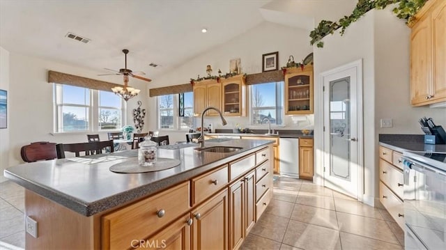 kitchen featuring a sink, dishwasher, an island with sink, dark countertops, and glass insert cabinets