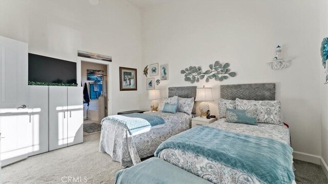 carpeted bedroom with a closet, a spacious closet, and baseboards