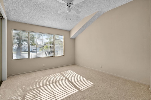 carpeted empty room with ceiling fan, a textured ceiling, and vaulted ceiling