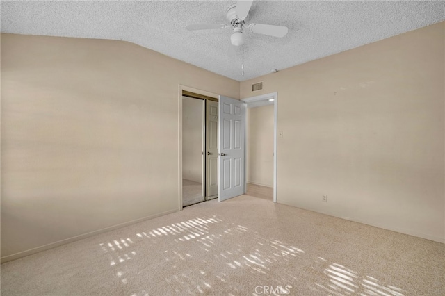 unfurnished bedroom featuring ceiling fan, a closet, a textured ceiling, and lofted ceiling