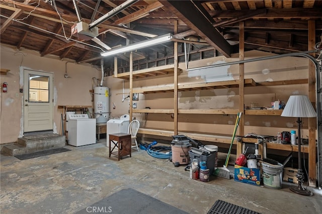 garage with washer and clothes dryer and secured water heater