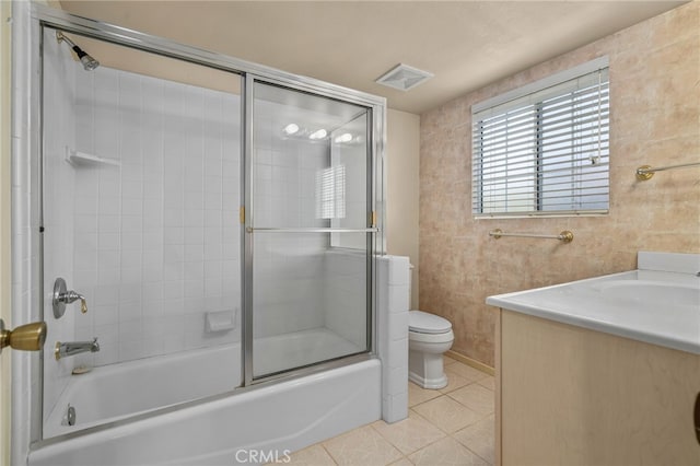 full bathroom featuring tile patterned floors, vanity, toilet, and combined bath / shower with glass door