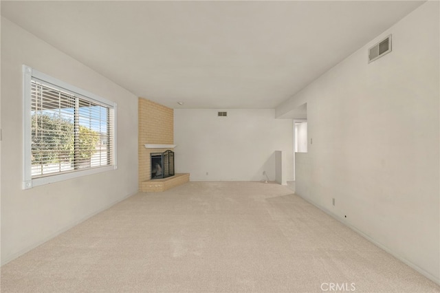 unfurnished living room featuring light carpet and a fireplace