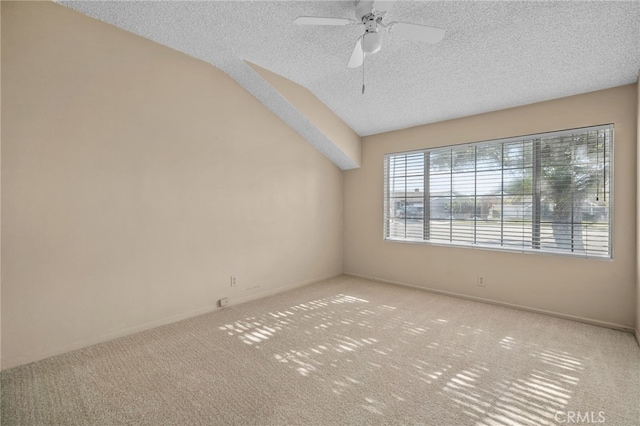 carpeted spare room with ceiling fan, a textured ceiling, and lofted ceiling