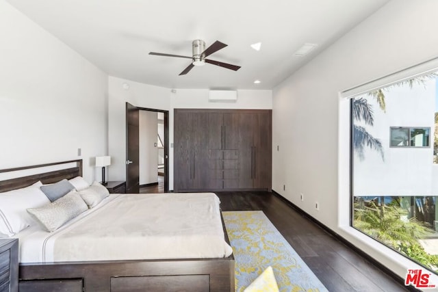 bedroom featuring ceiling fan, dark wood-type flooring, and a wall unit AC