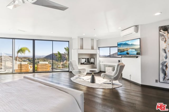 bedroom with access to outside, hardwood / wood-style flooring, a mountain view, and a wall mounted air conditioner