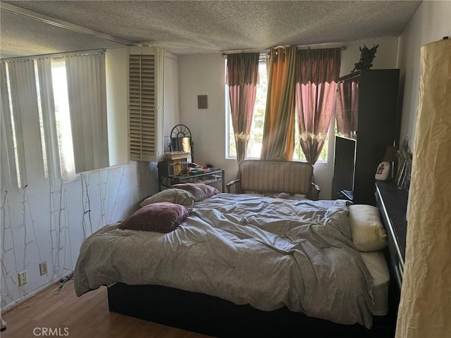 bedroom featuring a textured ceiling and hardwood / wood-style flooring