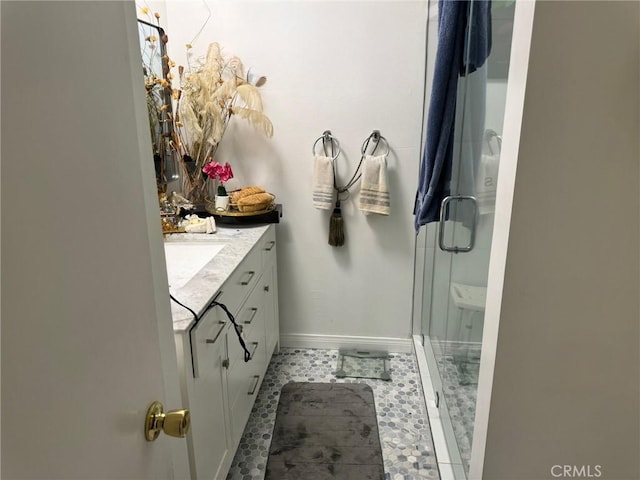 bathroom with tile patterned flooring, walk in shower, and vanity