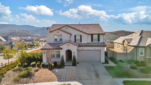 mediterranean / spanish-style home featuring a garage and a mountain view