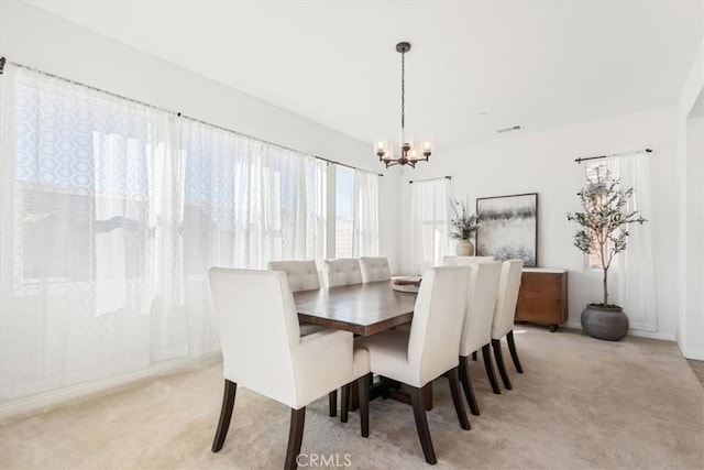 carpeted dining area featuring a notable chandelier