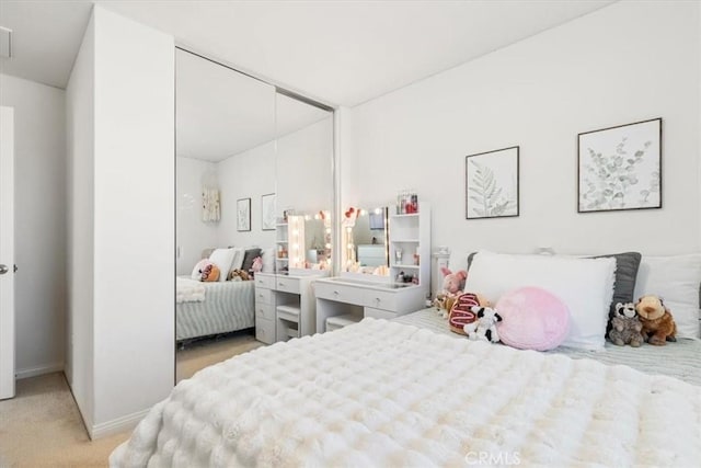 bedroom with light colored carpet and a closet