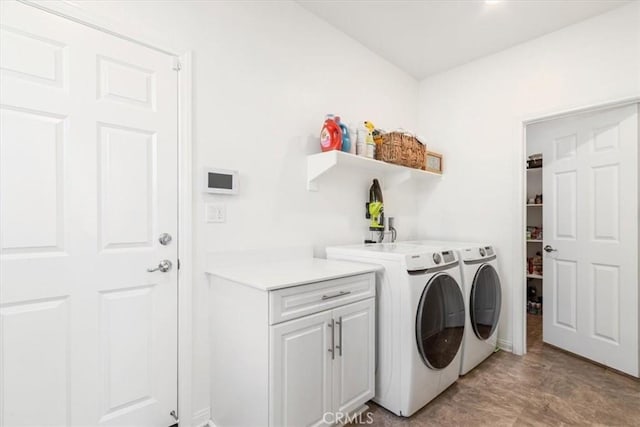 laundry area featuring washer and dryer and cabinets