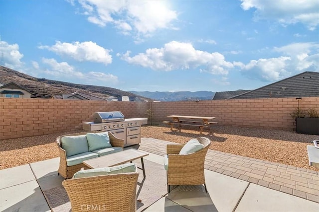 view of patio featuring an outdoor hangout area, a mountain view, and grilling area