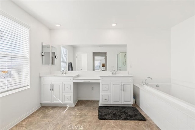 bathroom featuring vanity and tiled tub