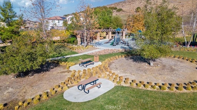 view of community featuring a playground and a lawn