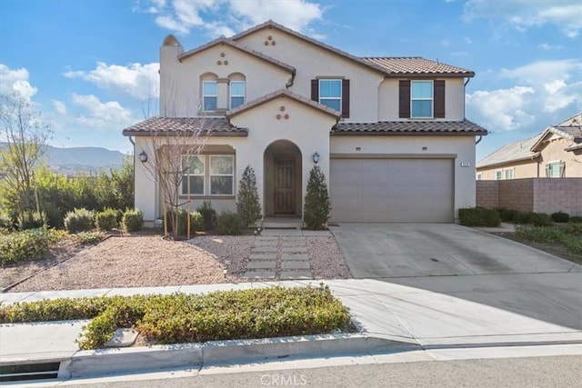 mediterranean / spanish-style house with a garage and a mountain view