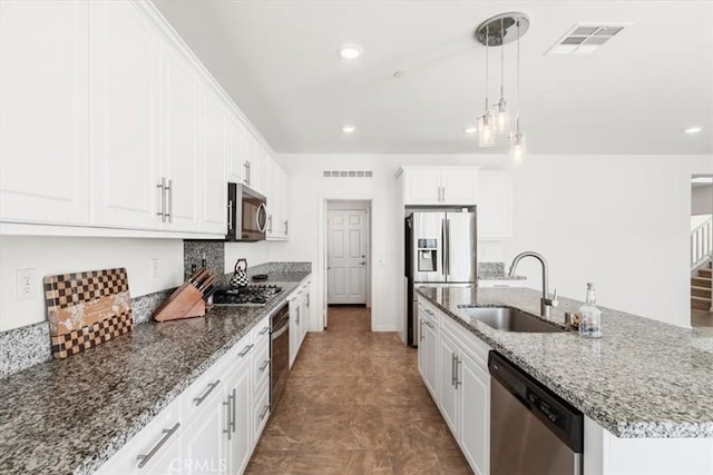 kitchen featuring stainless steel appliances, white cabinetry, hanging light fixtures, and sink