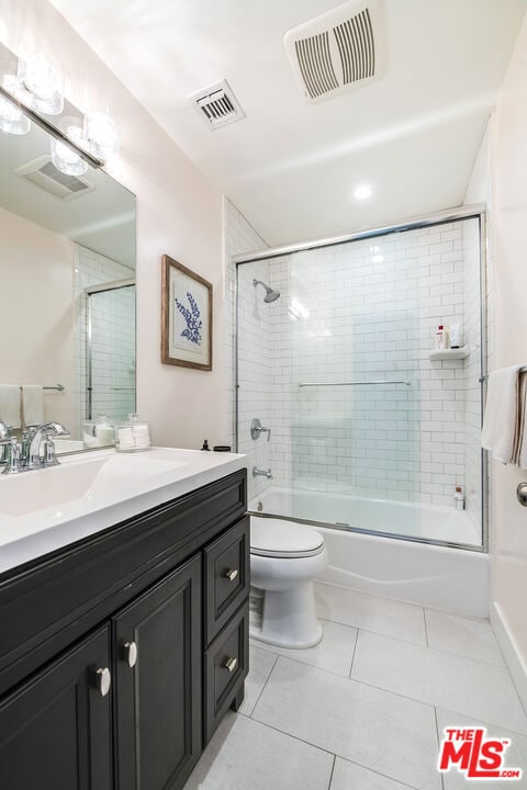 full bathroom with toilet, vanity, tile patterned flooring, and shower / bath combination with glass door