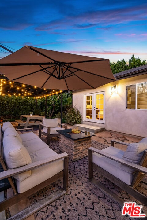 patio terrace at dusk with french doors and an outdoor hangout area