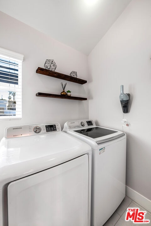 laundry room featuring independent washer and dryer and light tile patterned flooring