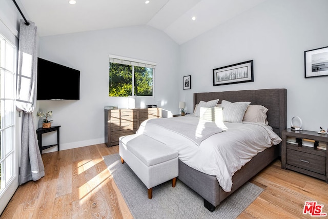 bedroom with light wood-type flooring and vaulted ceiling