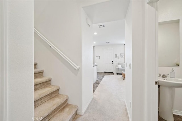 stairs with carpet floors and sink