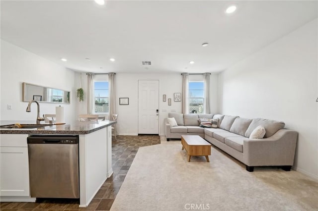 living room featuring sink and a healthy amount of sunlight