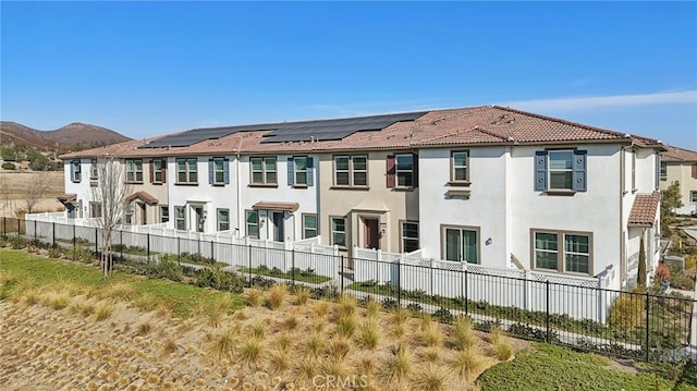 rear view of house featuring a mountain view and solar panels