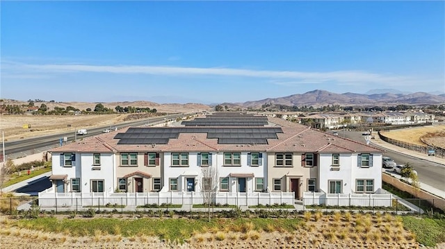 rear view of property with a mountain view and solar panels