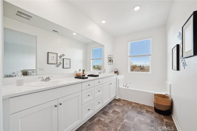 34495 Agave Dr Unit 1103, Winchester, CA 92596 - full bath featuring double vanity, visible vents, a garden tub, stone finish flooring, and a sink