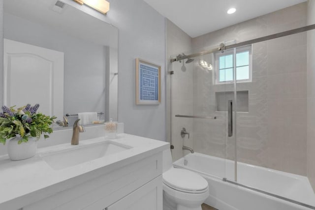 full bathroom featuring vanity, toilet, and bath / shower combo with glass door