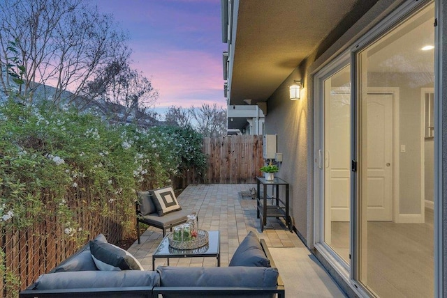 patio terrace at dusk featuring an outdoor living space