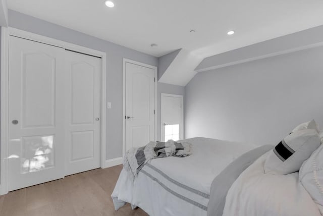 bedroom featuring light wood-type flooring and lofted ceiling