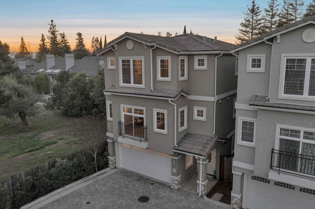 view of front of home featuring a balcony and a garage