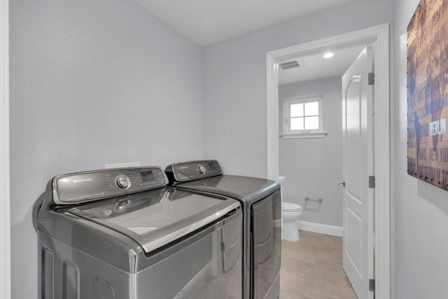 clothes washing area with washing machine and dryer