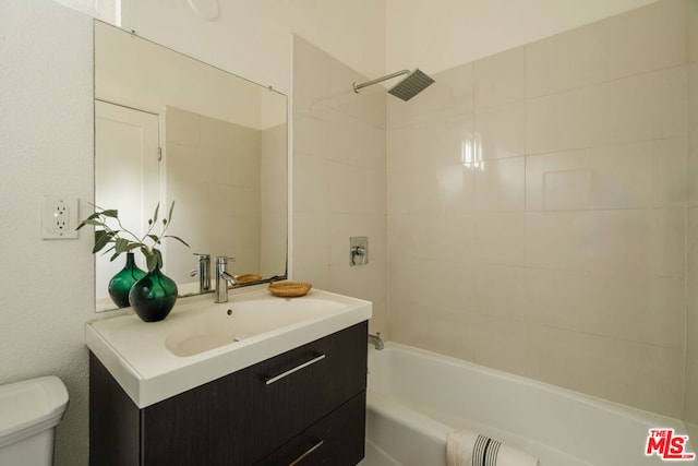 full bathroom with toilet, vanity, and tiled shower / bath