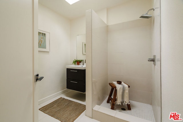 bathroom featuring tile patterned floors, vanity, and a tile shower